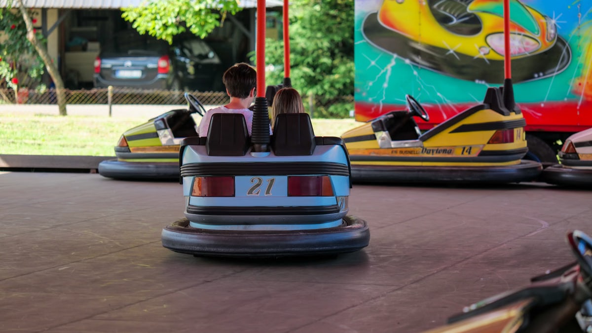 Kids having fun on bumper cars at Garešnica fairground. Exciting entertainment activity outdoors.